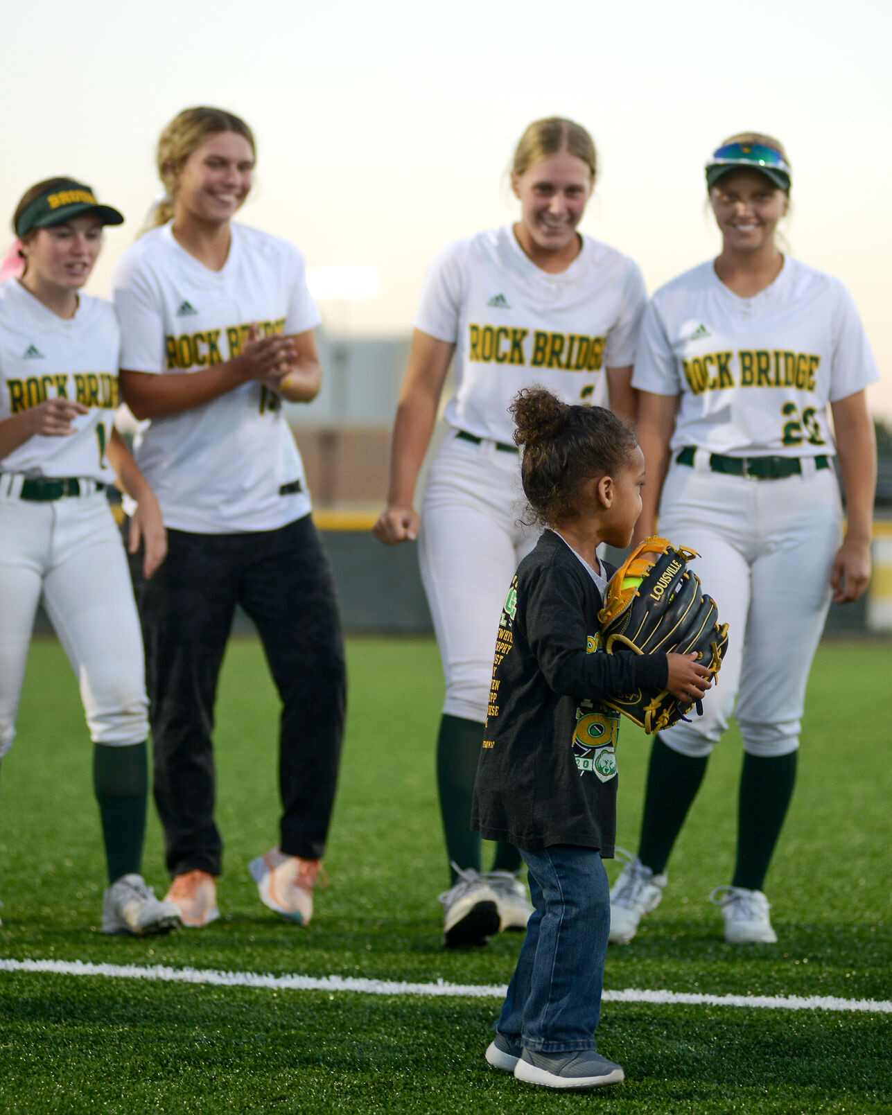 From left, Lucy Sadewhite, Molly Murphy, Anna Christ, and Elizabeth Wiese stand with Lachlen Alvis, son of head coach, Lisa Simmons Alvis